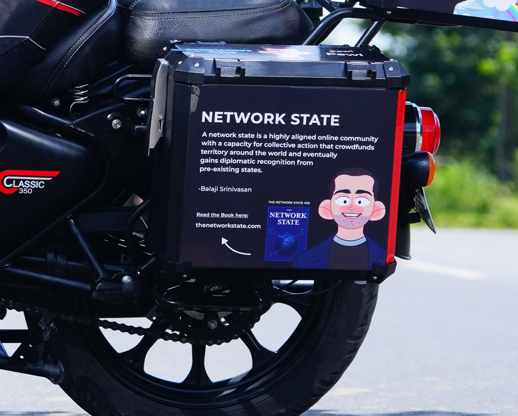 Close-up of Network State sticker with Balaji Srinivasan quote on Royal Enfield pannier